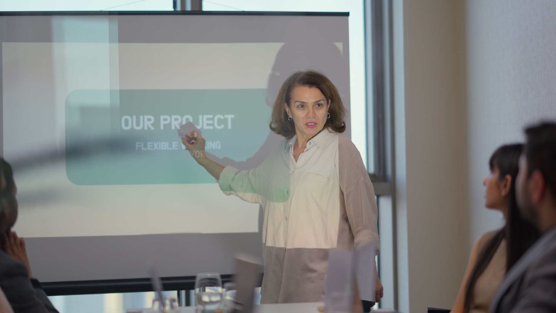 Mature businesswoman using slide shows and giving speech in office